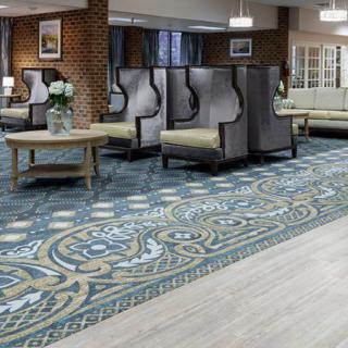 A spacious lobby area with stylish chairs and a patterned carpet.