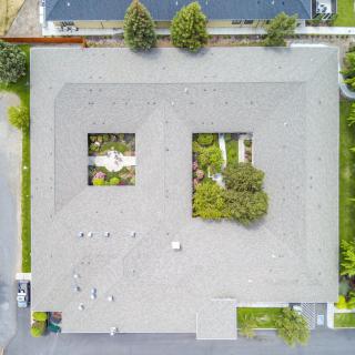 Aerial view of a residential building with open courtyards and surrounding greenery.