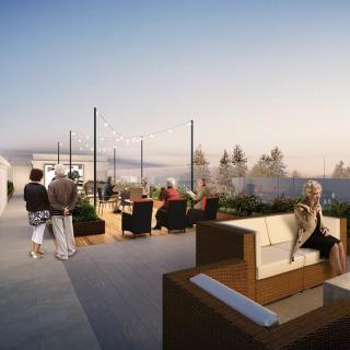 A scenic rooftop with people enjoying outdoor seating and a beautiful sunset city view.