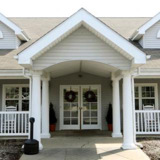 Front entrance of a house with columns and a porch.