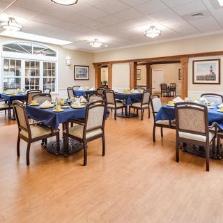 A well-arranged dining room with tables and chairs set for guests.