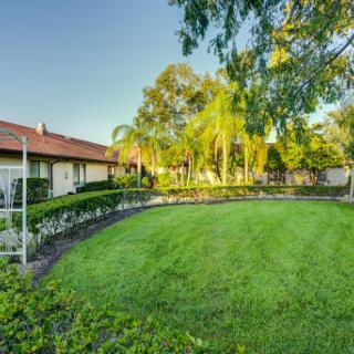 A serene backyard with lush green grass and palm trees, perfect for relaxation.