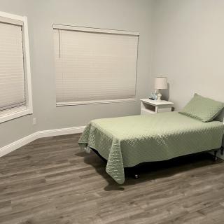 A minimalist bedroom with a single bed and nightstand.