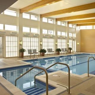 A modern indoor swimming pool with ample natural lighting from large windows.