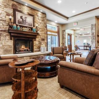 A cozy living room with a stone fireplace and comfortable seating.