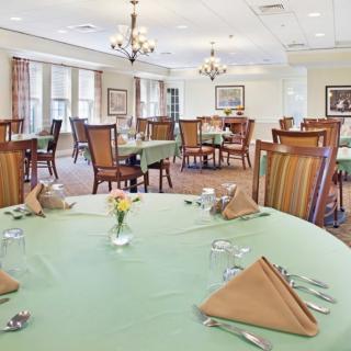 An elegant dining room with neatly arranged tables and warm lighting.