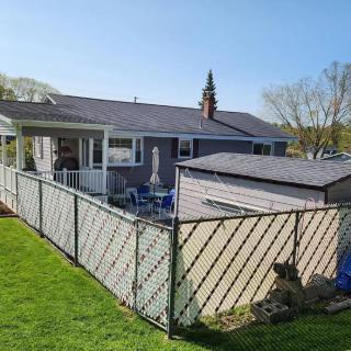 A suburban house with a fenced backyard and lawn.