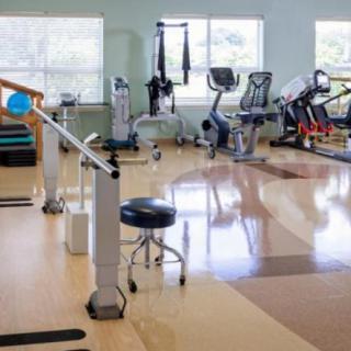 A rehabilitation room with various exercise equipment for physical therapy.