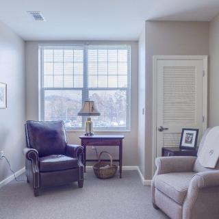 A cozy living room with comfortable armchairs and a side table by the window.