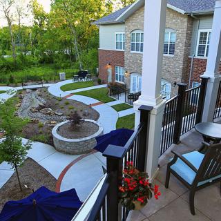 A well-landscaped backyard with a patio, outdoor seating, and a fire pit.