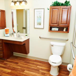 A well-designed bathroom featuring a toilet, sink, and wooden cabinets.