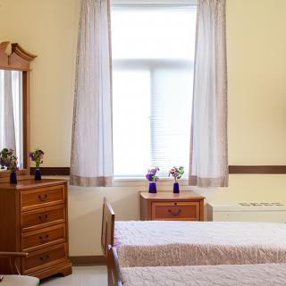 A cozy bedroom featuring wooden furniture and soft lighting.