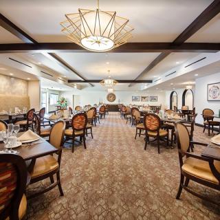 A spacious and elegantly decorated dining room with neatly arranged tables and chairs.