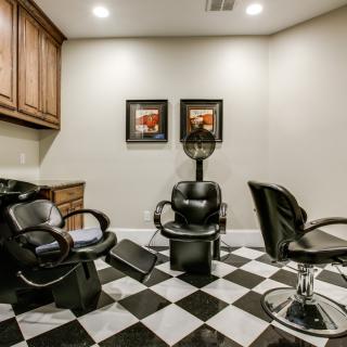 A small hair salon room featuring barber chairs and a checkered floor.