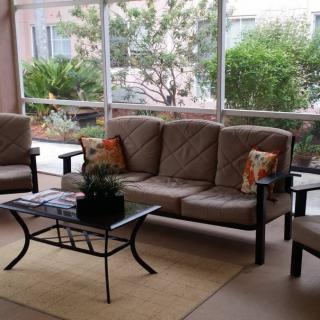 A cozy patio seating area with comfortable furniture and greenery.