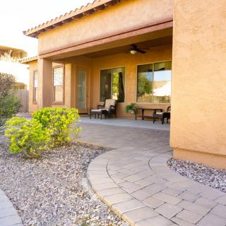 A cozy home patio with outdoor seating and desert landscaping.