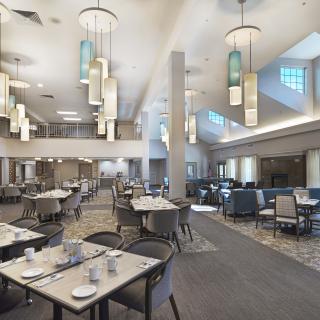 A spacious and modern dining area with elegant lighting and well-arranged tables.