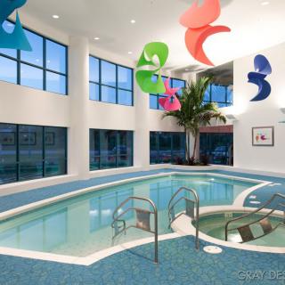 A modern indoor swimming pool with colorful decor and large windows.