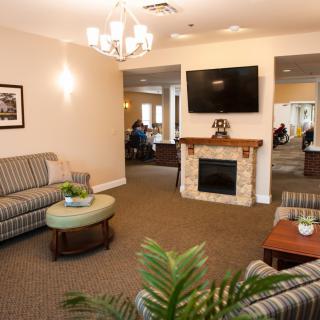 A cozy living room with sofas, a fireplace, and a television.
