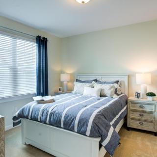 A cozy bedroom with a neatly made bed and stylish decor.