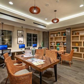 A modern office space featuring computers, bookshelves, and comfortable seating for meetings.