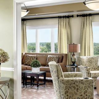 A cozy living room with elegant furnishings and large windows.