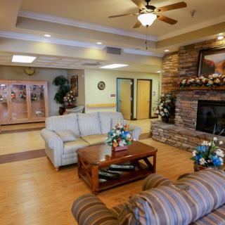 A cozy living room with comfortable seating, a stone fireplace, and warm decor.