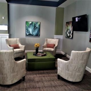 A modern seating area with four chairs surrounding a central table, adorned with stylish artwork on the walls.