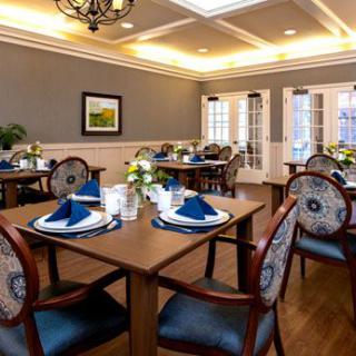 An elegantly furnished dining area with neatly arranged tables and chairs.