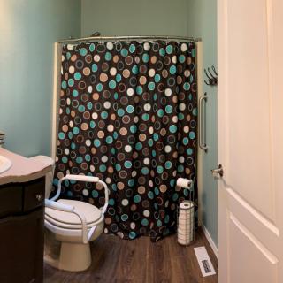 A cozy bathroom with a colorful polka dot shower curtain.