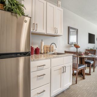 A modern kitchen with stainless steel appliances and a dining area.