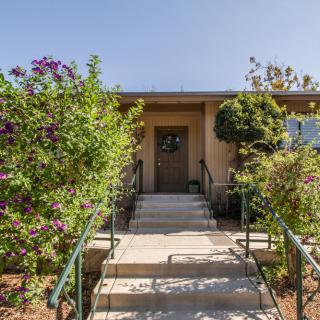 A house entrance with a pathway and lush garden.