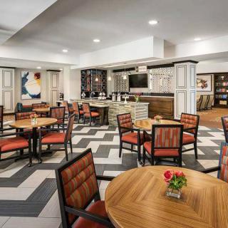 A modern restaurant dining area with neatly arranged tables and chairs, featuring stylish interior design.