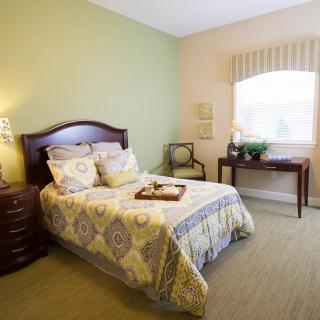 A cozy bedroom with a neatly made bed, elegant furniture, and soft lighting.
