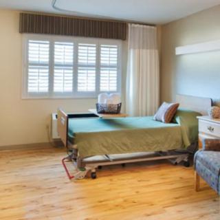 A clean and tidy hospital room with a bed and window.