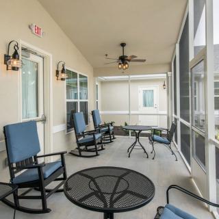 A spacious screened-in patio with comfortable seating and ceiling fans.