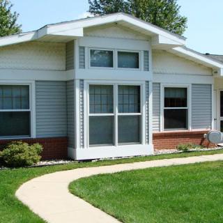 A single-story house with a well-maintained lawn and pathway leading to the entrance.