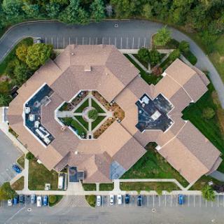 Aerial view of a complex with a central courtyard and surrounding parking.