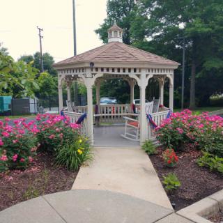 A charming gazebo surrounded by vibrant flowers in a peaceful park setting.