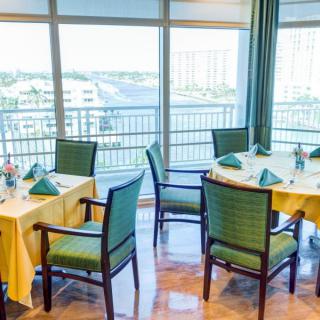 A bright dining area with neatly set tables and a view of the cityscape.