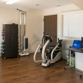 A well-equipped home gym with various workout machines and weights.