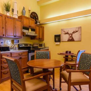 A cozy kitchen and dining area with wooden cabinets, a round table, and chairs.