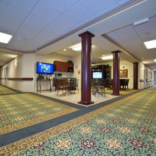 A spacious lobby area with patterned carpet and televisions.