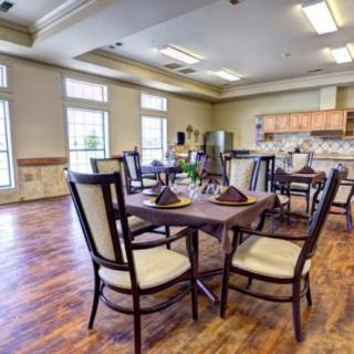 A bright and spacious dining room with elegant furniture and a kitchen area.