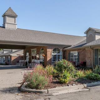 A spacious building with a brick exterior and well-maintained landscaping at its entrance.