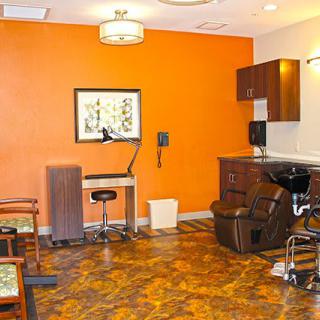 Modern salon interior with an orange accent wall and hair styling station.
