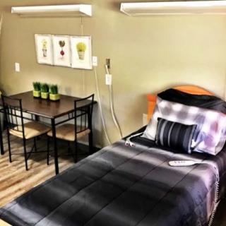 A modern bedroom with a single bed and small dining table.