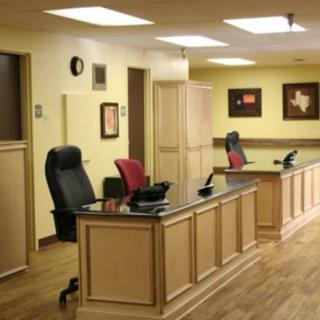 Modern office reception area with desks and chairs.