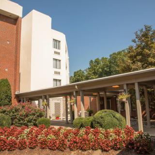 A hotel building with landscaped gardens and a covered entrance.