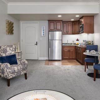 A cozy apartment living area with a small kitchenette and modern furnishings.